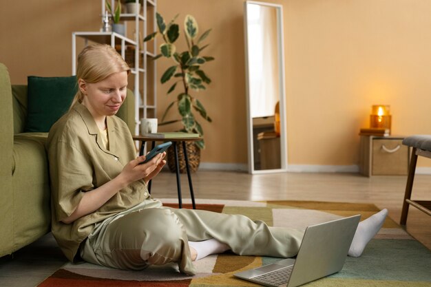 Full shot albino woman sitting on floor