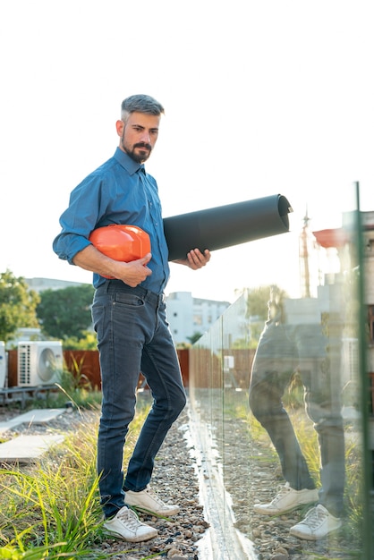 Full shot of architect holding blueprints