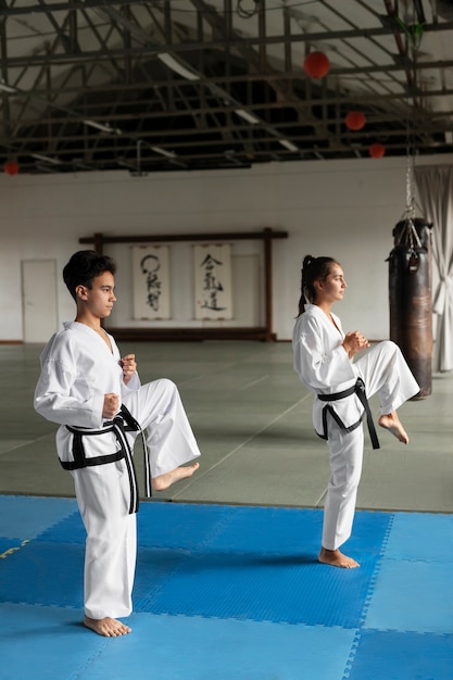 Full shot asian people practicing taekwondo