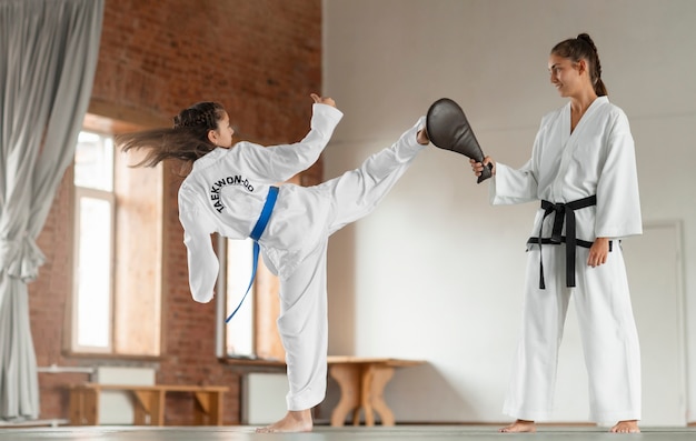 Full shot asian people practicing taekwondo