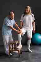 Free photo full shot athlete at physiotherapy