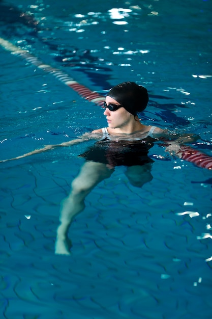 Full shot athlete swimming with goggles