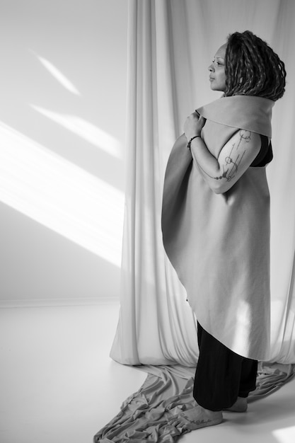 Full shot authentic woman in studio with curtain