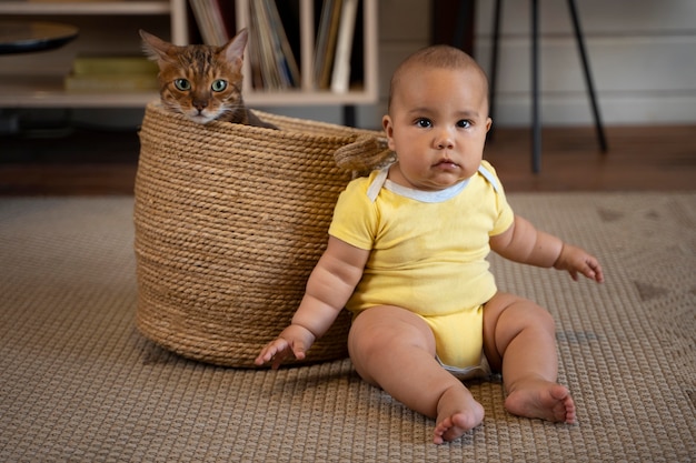 Foto gratuita bambino a tutto campo e gatto nel cestino