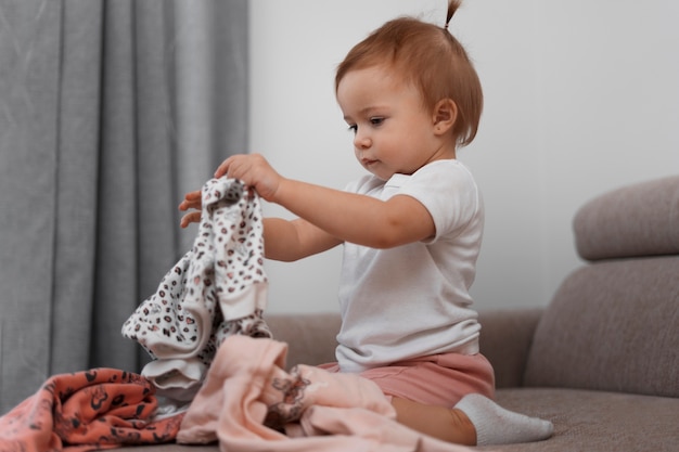 Foto gratuita vestiti della tenuta del bambino del colpo pieno