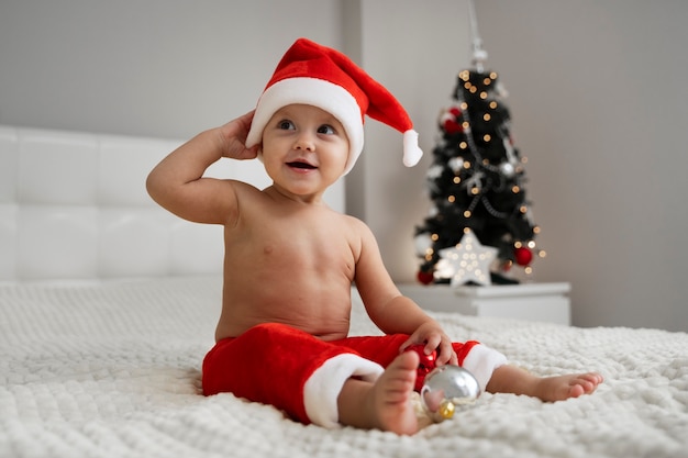 無料写真 サンタの帽子をかぶったフルショットの赤ちゃん