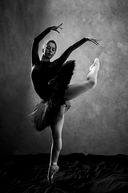 Foto gratuita scala a tutto schermo con le prestazioni della ballerina in scala di grigi