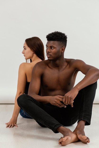 Free photo full shot black man and white woman sitting