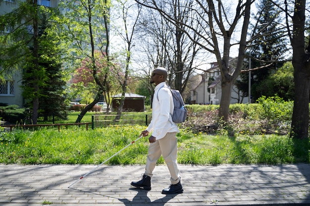 Free photo full shot blind man walking with cane