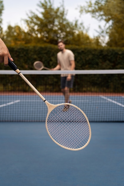 Full shot blurry man playing badminton