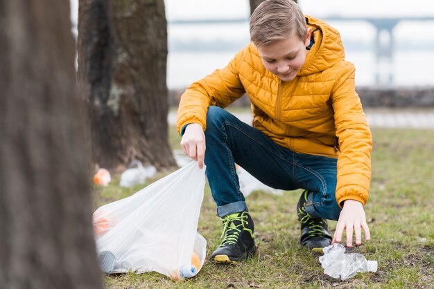 Full shot of boy cleaning the ground