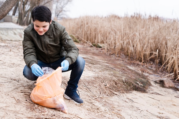 Full shot of boy cleaning the ground