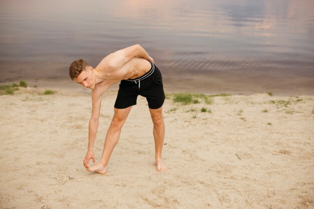 Free photo full shot boy exercising near the lake