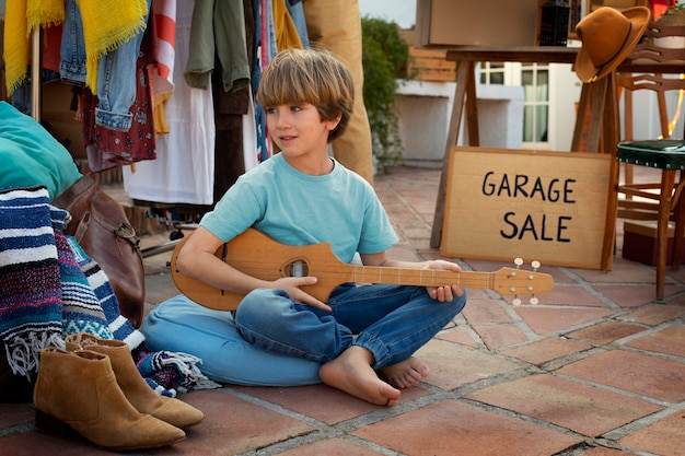 Foto gratuita ragazzo a tutto campo alla vendita di garage