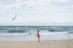 Free photo full shot boy  having fun at the beach