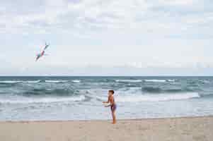 Foto gratuita ragazzo a tutto campo che si diverte in spiaggia