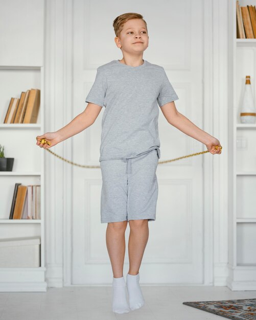 Full shot boy jumping rope inside