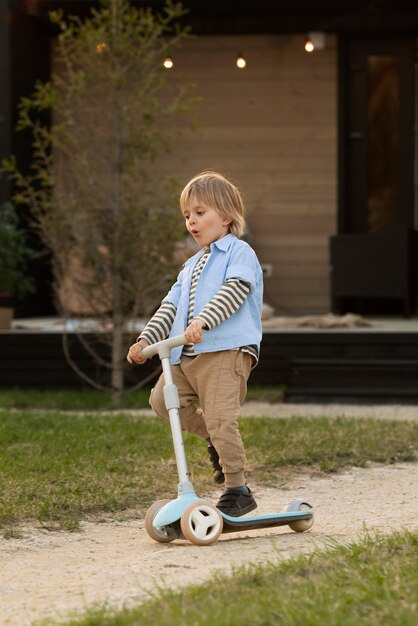 Full shot boy playing with scooter