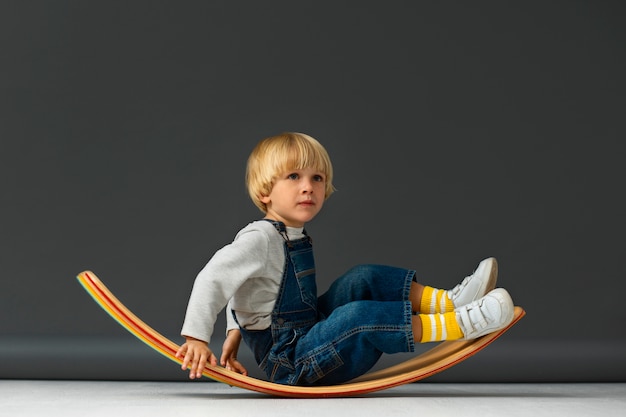 Free photo full shot boy sitting in studio