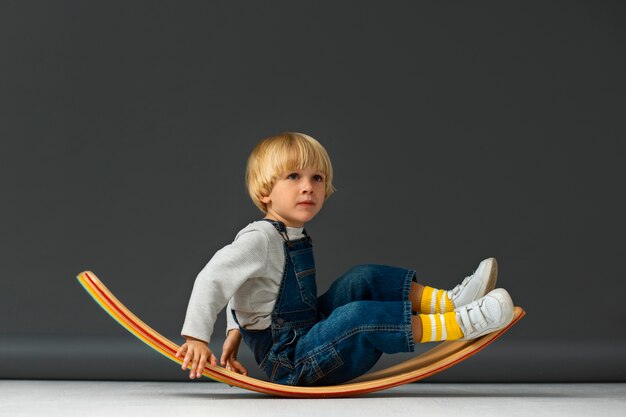 Full shot boy sitting in studio