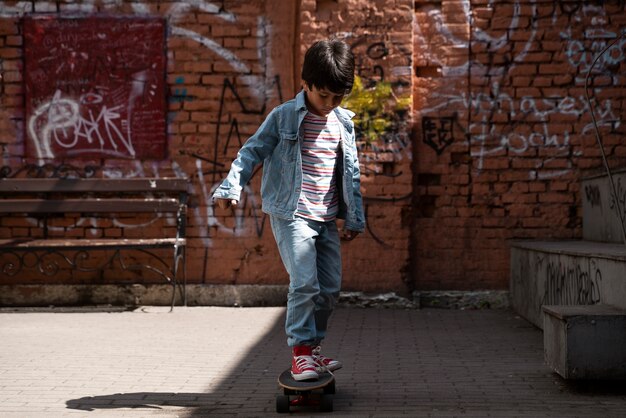 スケートボードのフルショットの少年