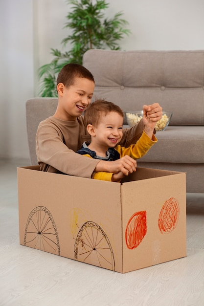 Full shot brothers playing with box