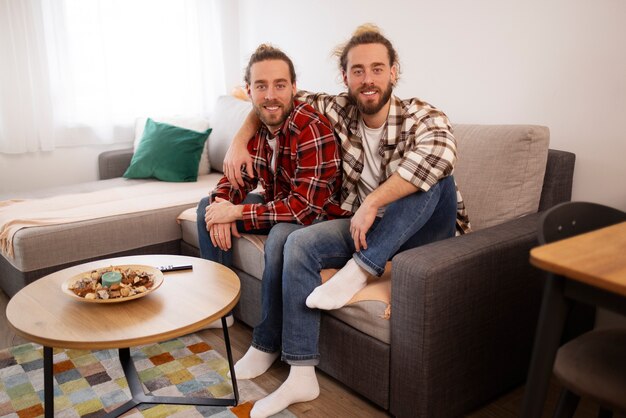 Full shot brothers sitting on couch