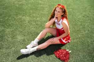 Free photo full shot cheerleader sitting outdoors