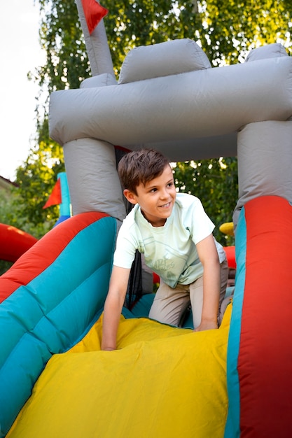 Full shot child having fun in bounce house