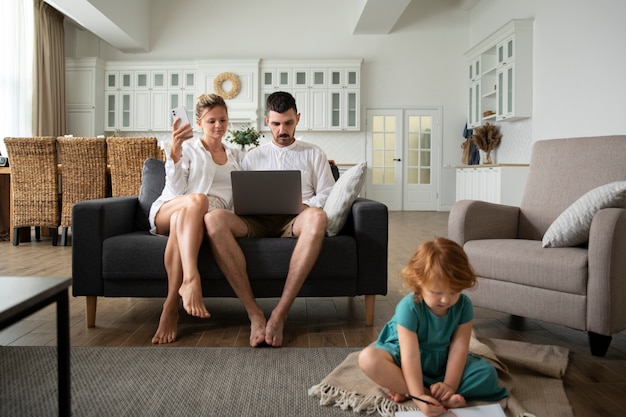 Full shot child and parents with laptop