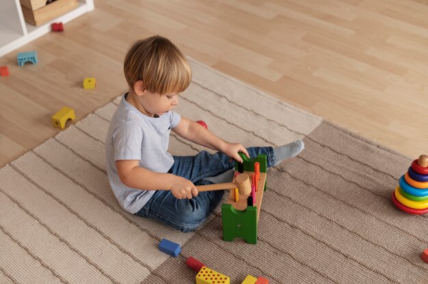 木のおもちゃで遊ぶフルショットの子供