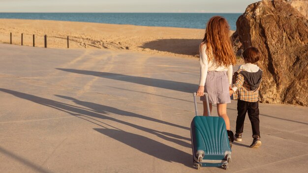 Full shot children carrying baggage