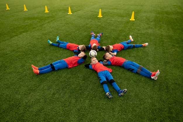 Full shot children laying on grass