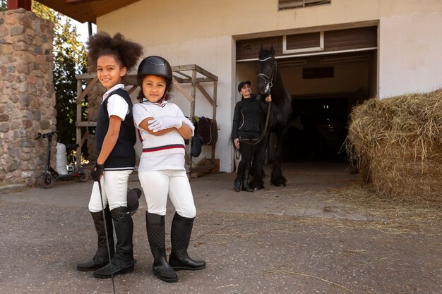 Full shot children learning to ride horses