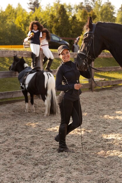 Полный снимок детей, которые учатся кататься на лошадях