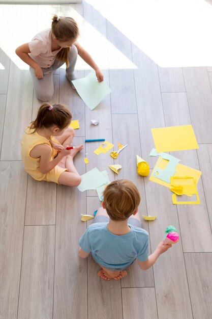 紙で遊ぶフルショットの子供たち