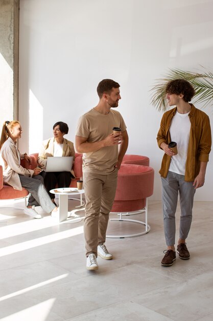 Full shot colleagues with coffee cups