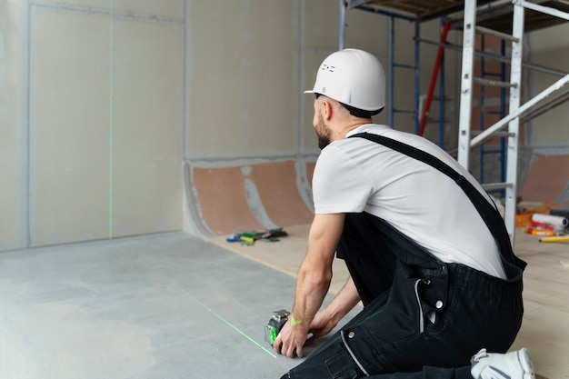 Full shot construction worker holding tool