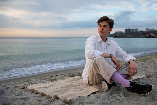 海辺のフルショットの瞑想的な男性