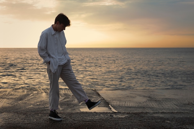 Foto gratuita uomo contemplativo a figura intera in riva al mare