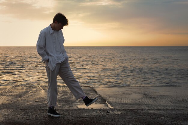 海辺のフルショットの瞑想的な男性