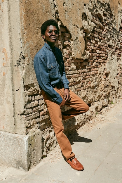 Full shot cool black man posing with sunglasses