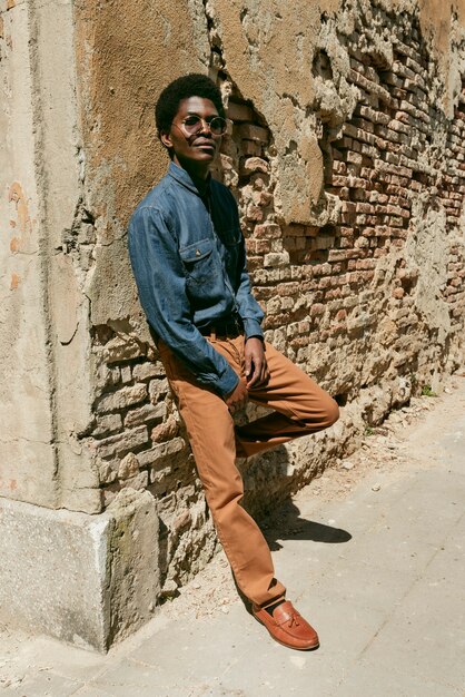 Full shot cool black man posing with sunglasses