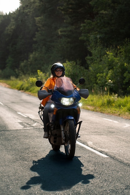 Full shot cool old woman with motorbike