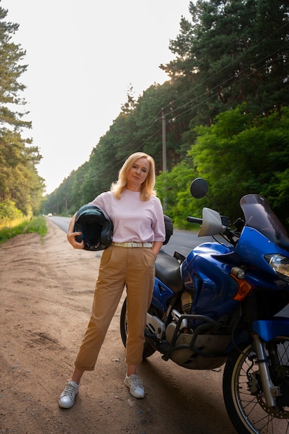 Full shot cool old woman with motorbike