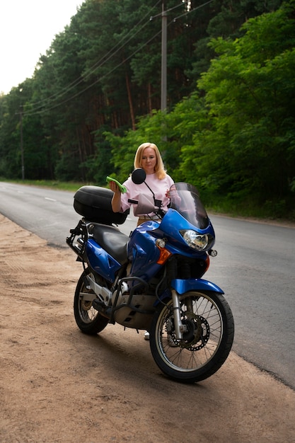 Full shot cool old woman with motorbike