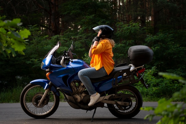 Full shot cool old woman with motorbike