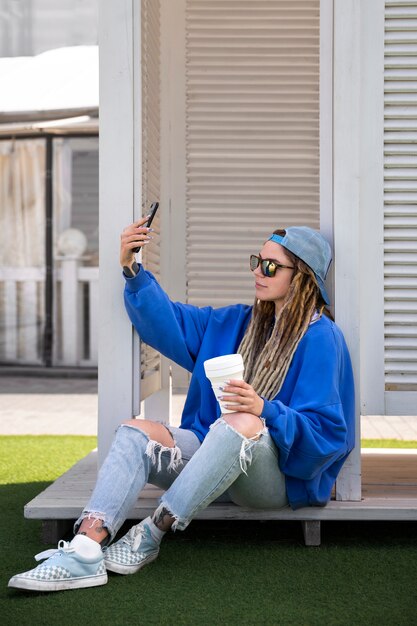 Full shot cool woman taking selfie