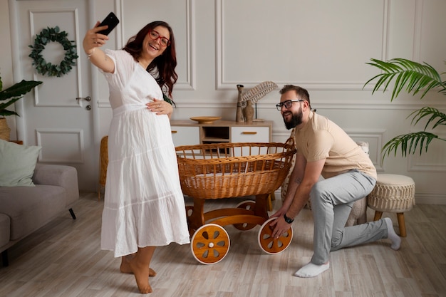 Free photo full shot couple announcing pregnancy with smartphone