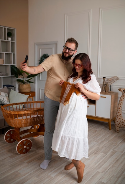 スマートフォンで妊娠を発表するフルショットのカップル